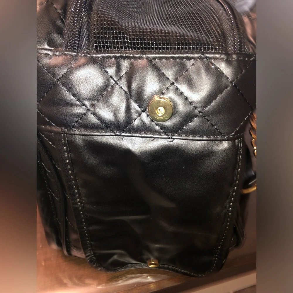 black quilted pet carrier tote with gold chain handles.